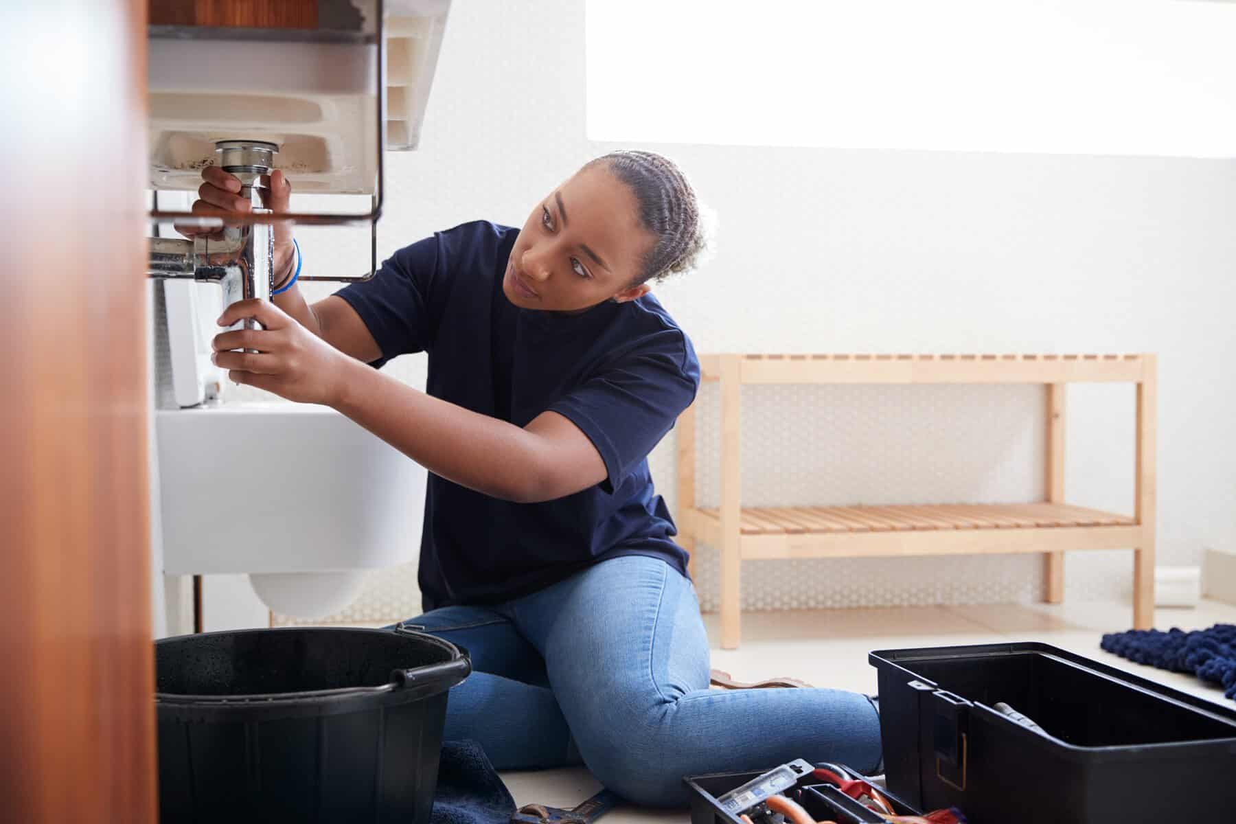 female plumber working to fix leaking sink in home 2023 11 27 05 26 19 utc