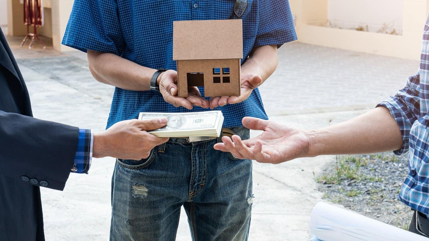 agent giving money customer while client holding model house outdoors
